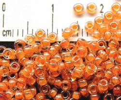 Rocailles 
 kristall mit Farbeinzug orange /schimmernd (lüster)